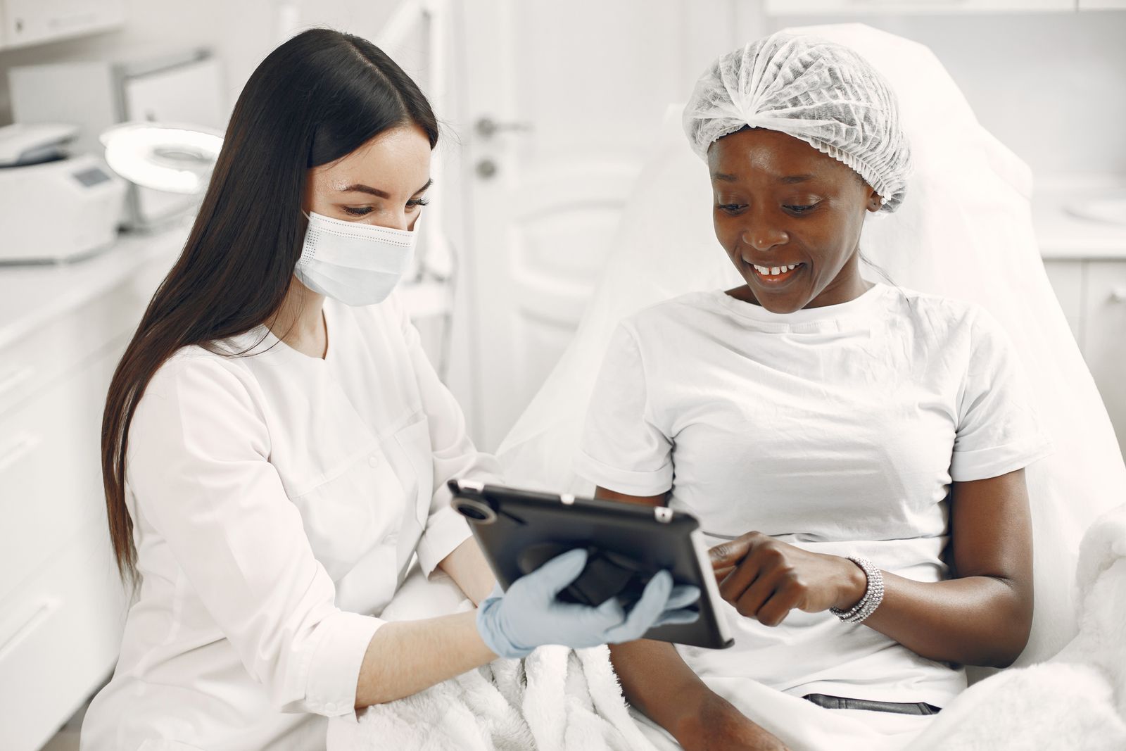 Dermatology specialist reviewing information with a patient on a tablet